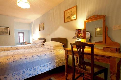 a bedroom with a bed and a desk with a mirror at The Manor at Plane Castle in Falkirk