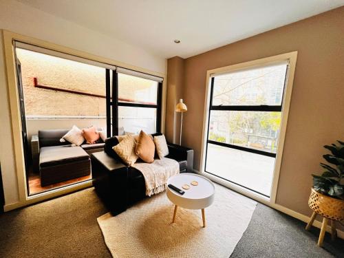 a living room with a couch and a large window at Studio Apartment in Auckland CBD in Auckland