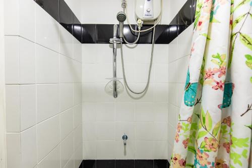 a shower in a bathroom with a shower curtain at District Inn in Manila