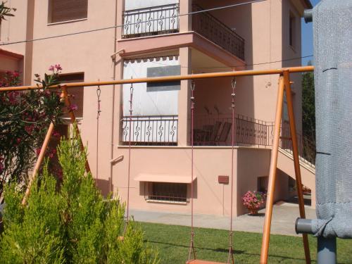 an apartment building with a porch and a swing at Villa Angela in Sikia