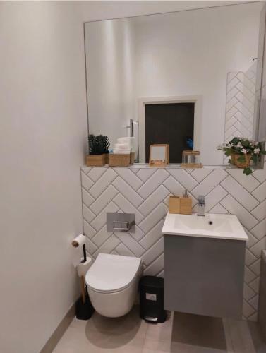 a white bathroom with a toilet and a sink at Modern 2bed Sutton in Sutton