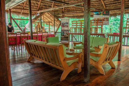Caiman Eco Lodge في Aguarico: مجموعة من الكراسي والطاولات في المطعم
