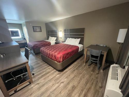 a hotel room with two beds and a desk at Econo Lodge Inn & Suites Murfreesboro Shopping District in Murfreesboro
