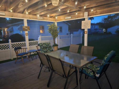 eine Terrasse mit einem Tisch und Stühlen auf einer Terrasse in der Unterkunft Bungalow by the Beach in Hampton