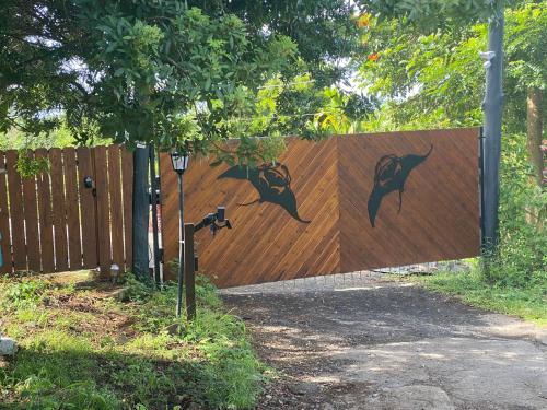 a wooden fence with dolphins painted on it at Manta Soul Jungle Geodome in Kealakekua