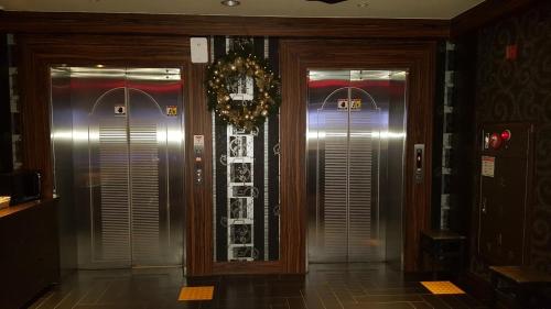 a hallway with two elevators in a building at Sky Hotel in Hwaseong