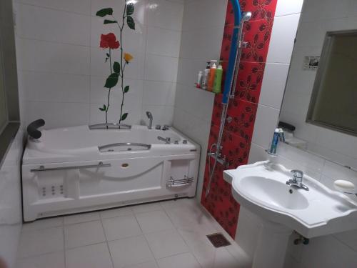 a bathroom with a bath tub and a sink at Sky Hotel in Hwaseong