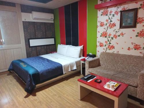 a hotel room with a bed and a couch at Sky Hotel in Hwaseong