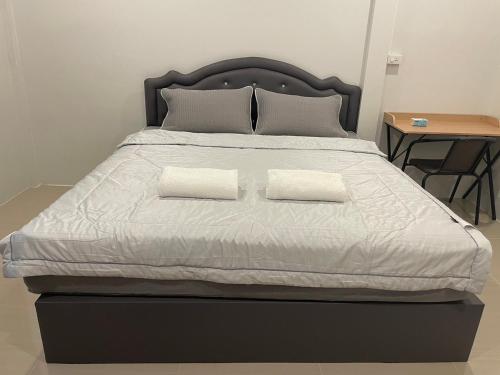 a large bed with two white pillows on it at Phu Thai Resort in Sukhothai