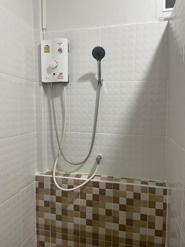 a shower in a bathroom with a hose on the wall at Phu Thai Resort in Sukhothai
