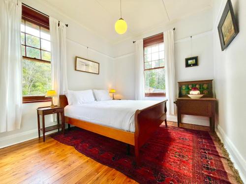 - une chambre avec un lit et 2 fenêtres dans l'établissement Violet's Maison, à Katoomba