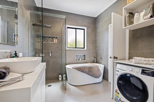 a bathroom with a sink and a washing machine at Bayview House with SAUNA and SPA by Ready Set Stay in Cowes