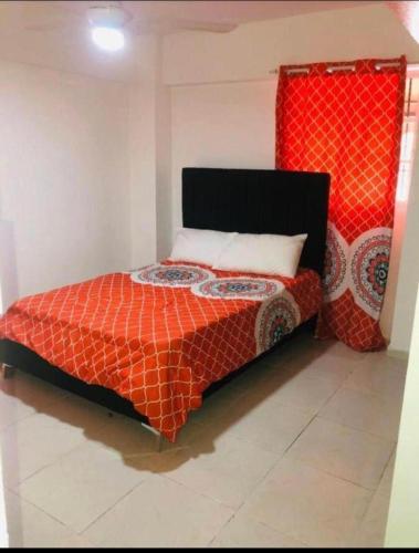 a bedroom with a bed with a red comforter at RESIDENCIAL VALENCIA 1B in La Viva