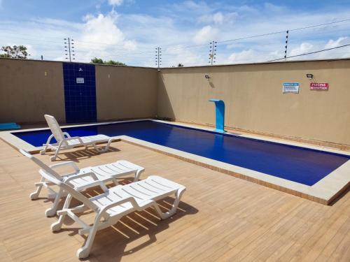 una piscina en la parte superior de un edificio con sillas en Dunas Residence - Casa 10 en Santo Amaro