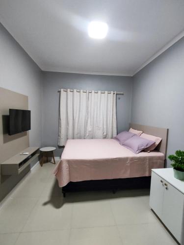 a bedroom with a large bed and a television at Dunas Residence - Casa 10 in Santo Amaro