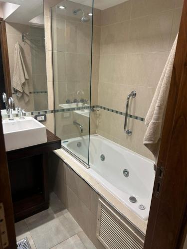 La salle de bains est pourvue d'une douche, d'une baignoire et d'un lavabo. dans l'établissement Del Bono Suites ART San Juan, à San Juan