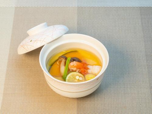 a bowl of soup sitting on top of a table at Ishinoya Izunagaoka - TKP Hotels & Resorts in Izunokuni
