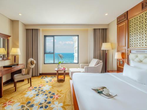 a hotel room with a bed and a view of the ocean at DLG Hotel Danang in Da Nang