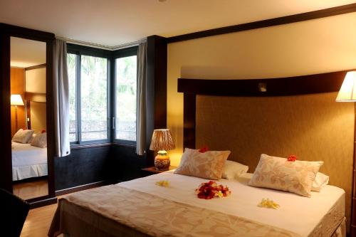 una camera da letto con un grande letto con fiori di Tahiti Lafayette Beach Lodge ad Arue