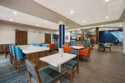 a dining room with tables and chairs at Holiday Inn Express & Suites Lexington by IHG in Lexington
