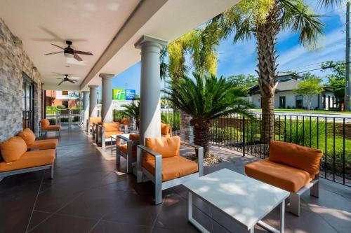 a porch with chairs and a table and palm trees at Holiday Inn Express & Suites Lexington by IHG in Lexington