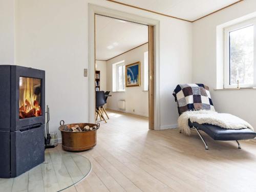 a living room with a fireplace and a chair at Seaside Charm in Gedser - By Traum Ferienwohnungen in Gedser