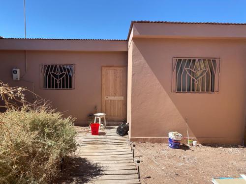 une maison avec une passerelle en bois devant elle dans l'établissement Casa Paso Jama, à San Pedro de Atacama