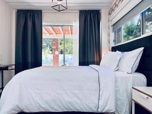 a bedroom with a white bed and a window at Conifer in Gold Coast