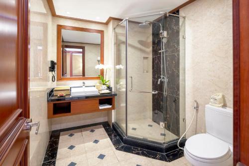a bathroom with a shower and a toilet and a sink at DLG Hotel Danang in Da Nang