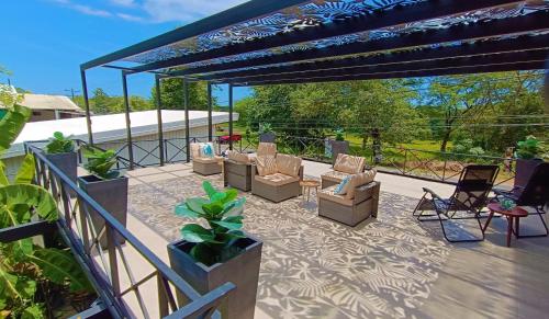 a patio with couches and chairs under a pergola at Suite Dream Blue in Tamarindo