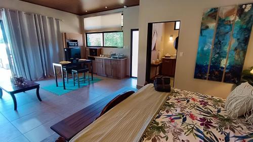 a room with a bed and a kitchen with a table at Suite Dream Blue in Tamarindo