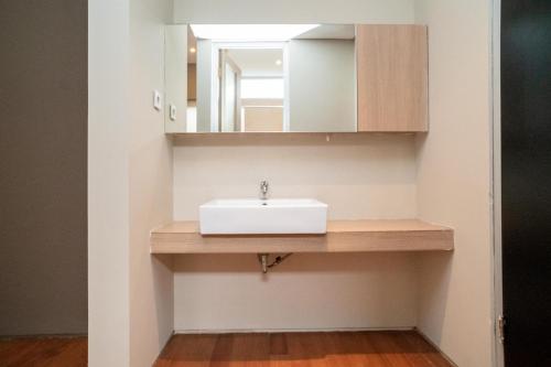 a bathroom with a sink and a mirror at 3J Home in Binong