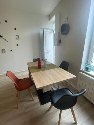 - une salle à manger avec une table et des chaises en bois dans l'établissement L échappée Belle, à Rochefort