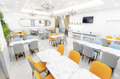a dining room with tables and yellow chairs at Ashton Hotel in Ulsan