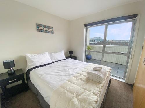 een slaapkamer met een wit bed en een groot raam bij The Landings Parnell in Auckland