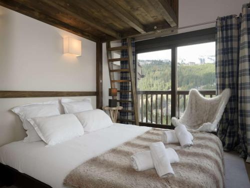 une chambre avec un lit avec des oreillers blancs et une fenêtre dans l'établissement Duplex de 120 m² à Courchevel 1650, pour 8 pers., Centre station, proche pistes avec cheminée et parking - FR-1-631-161, à Courchevel