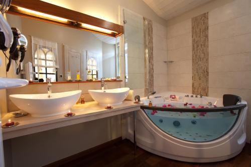 y baño con 2 lavabos y bañera. en Chambre d'hôtes Hôte des Portes Île de Ré, en Les Portes