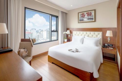 a hotel room with a bed and a large window at DLG Hotel Danang in Da Nang