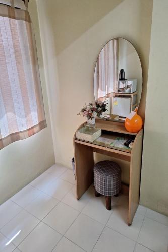 a vanity with a mirror and a desk in a room at MS Mansion in Bangkok