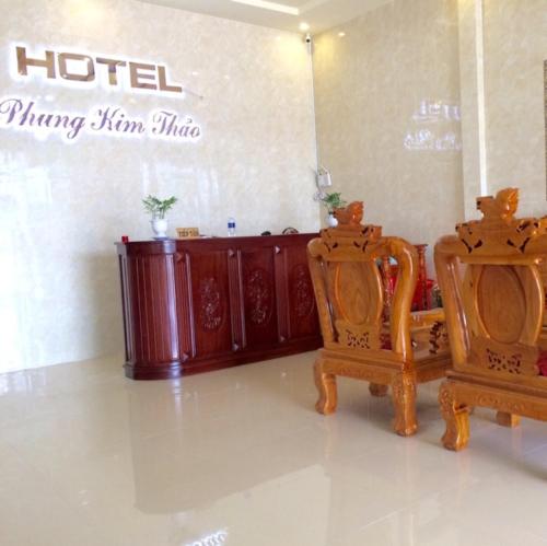 een kamer met 2 stoelen en een eetzaal van het hotel bij Phụng Kim Thảo Hotel Long An in Long An