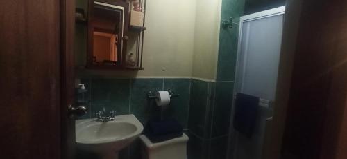 W łazience znajduje się umywalka, toaleta i lustro. w obiekcie Departamento Emily w mieście Cuenca
