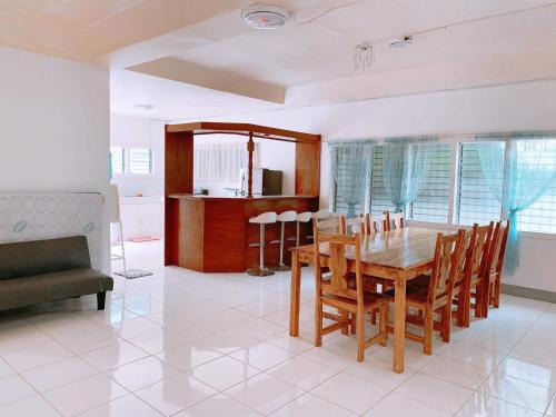 a kitchen and dining room with a wooden table and chairs at Luna Oslob Travellers Inn in Oslob