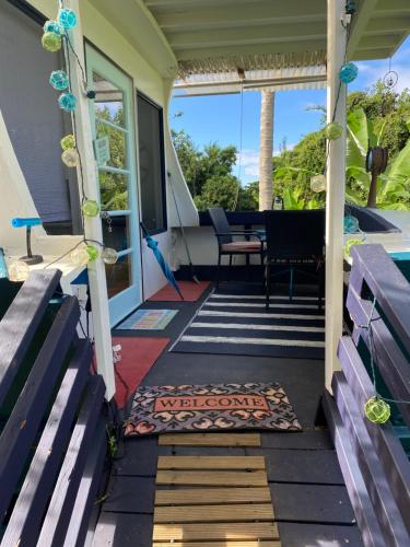 a screened porch with benches and a table at Cozy jungle boat hideaway with stunning ocean view in Kealakekua