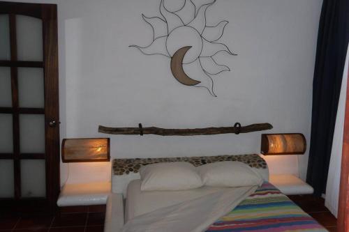 - une chambre avec un lit et deux lumières sur le mur dans l'établissement COZY APARTMENT IN A GREAT SPOT, à Puerto Escondido
