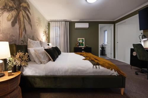 a bedroom with a large bed with a blanket on it at Kuca Stone in Daylesford