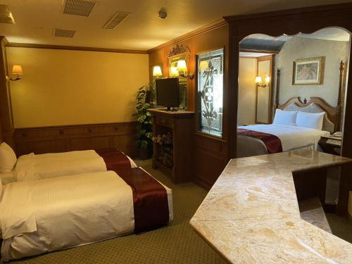 a hotel room with two beds and a television at I Live Motel in Kaohsiung