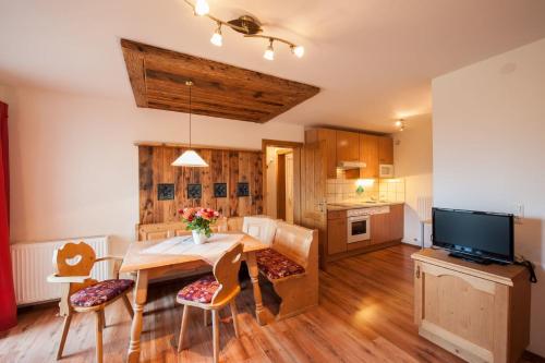 a kitchen and dining room with a wooden table and chairs at Zugspitzhotel Diana Thörle in Ehrwald