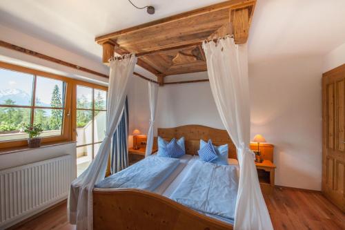 a bedroom with a bed with a canopy at Zugspitzhotel Diana Thörle in Ehrwald