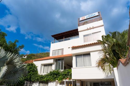 un edificio blanco con un cartel. en Hotel Zamay Plus, en Santa Marta