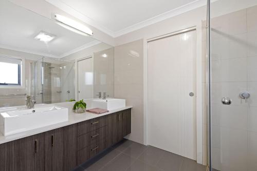 uma casa de banho branca com um lavatório e um chuveiro em Hazelwood em Cowes